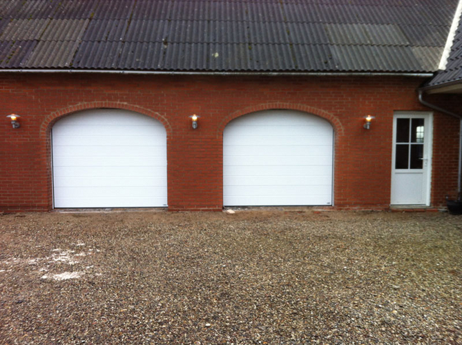 Garageport med bue, der passer til husets stil